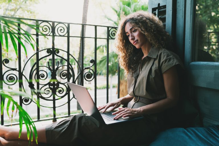 Chica con su ordenado portátil trabajando en su web profesional